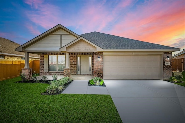 view of front of home featuring a lawn, covered porch, and a garage