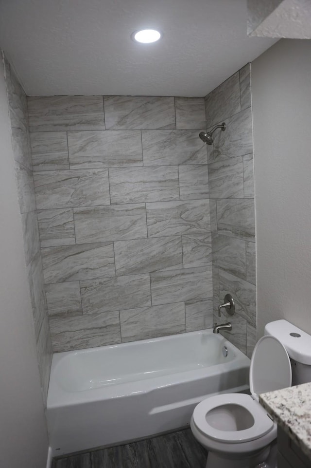 full bathroom with hardwood / wood-style flooring, toilet, vanity, and tiled shower / bath