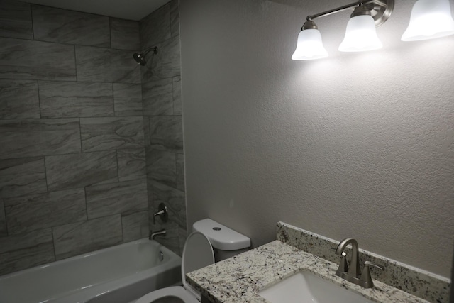 full bathroom featuring vanity, tiled shower / bath combo, and toilet