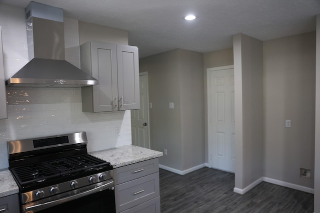 kitchen with gray cabinetry, wall chimney exhaust hood, and stainless steel gas stove