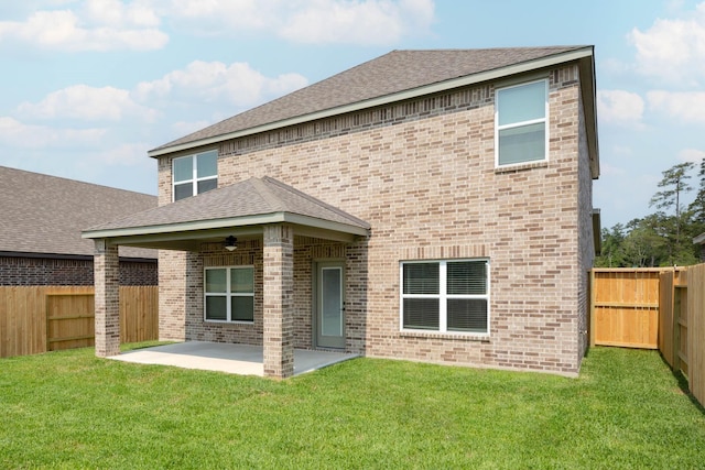 rear view of property with ceiling fan, a yard, and a patio