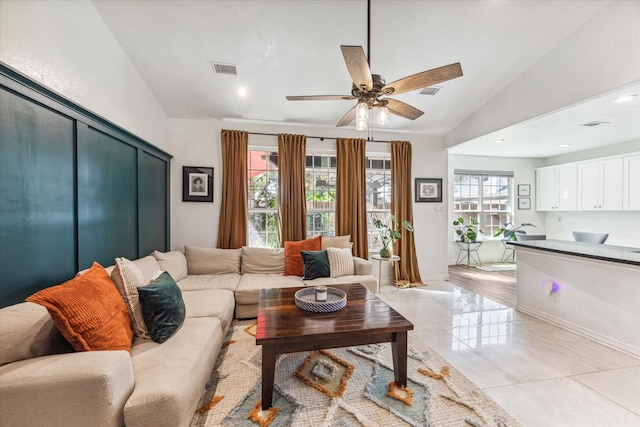 living room with a wealth of natural light, ceiling fan, and lofted ceiling