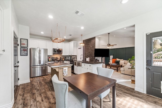 dining space featuring hardwood / wood-style flooring, ceiling fan, lofted ceiling, and sink