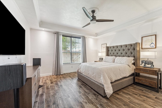 bedroom featuring a raised ceiling, ceiling fan, crown molding, and dark hardwood / wood-style floors