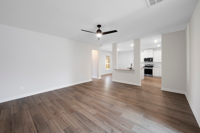 unfurnished living room with ceiling fan, light hardwood / wood-style flooring, and sink