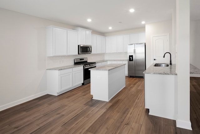 kitchen featuring a kitchen island with sink, dark wood-type flooring, sink, white cabinetry, and stainless steel appliances