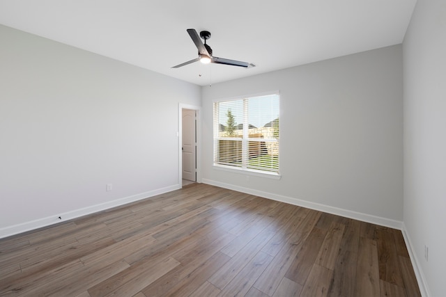 unfurnished room with ceiling fan and hardwood / wood-style flooring