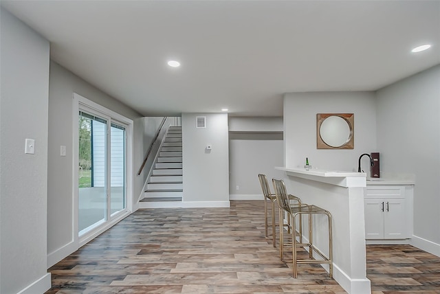 interior space with white cabinets, light wood-type flooring, and sink