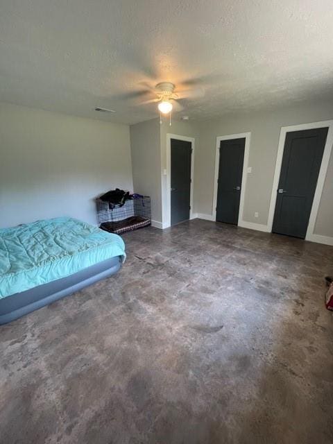 bedroom featuring ceiling fan, concrete floors, and a textured ceiling