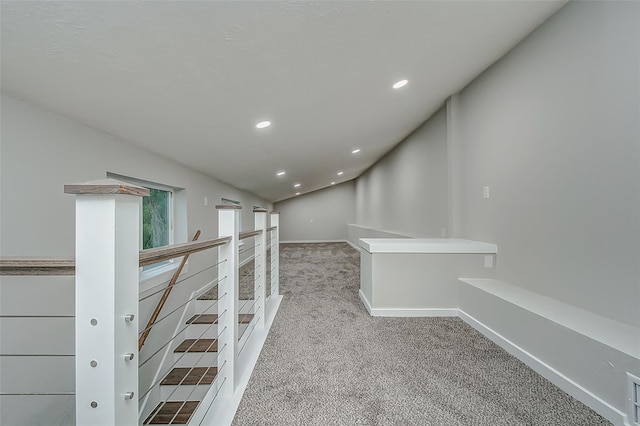 hall featuring light colored carpet and lofted ceiling