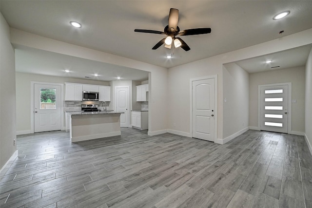 interior space featuring light hardwood / wood-style floors, ceiling fan, and sink