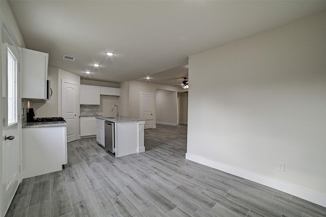 kitchen with ceiling fan, dishwasher, sink, an island with sink, and white cabinets