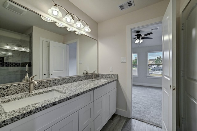 bathroom with ceiling fan, vanity, an enclosed shower, and hardwood / wood-style flooring