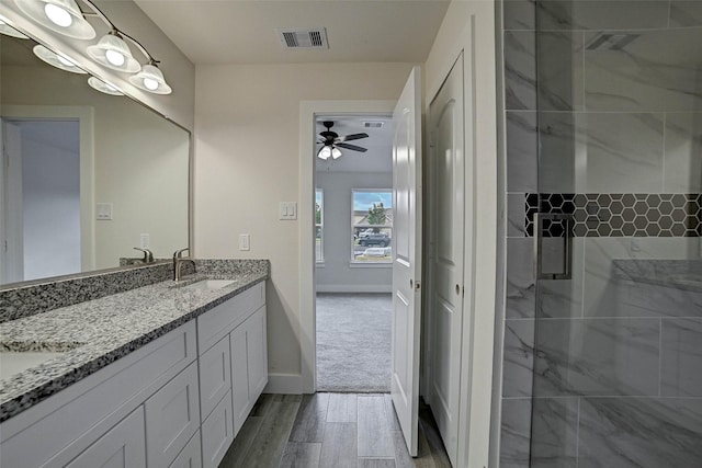 bathroom featuring vanity, ceiling fan, and a shower with shower door