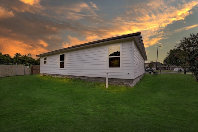 property exterior at dusk with a lawn