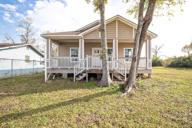 view of front of home with covered porch and a front lawn