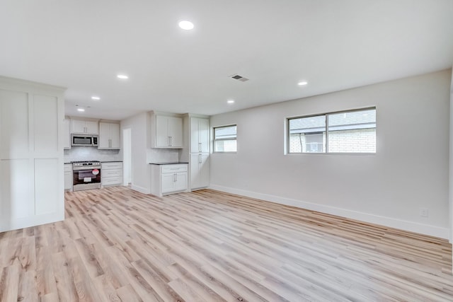 unfurnished living room with light hardwood / wood-style flooring and a wealth of natural light