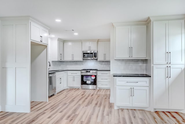 kitchen with white cabinetry, light hardwood / wood-style flooring, appliances with stainless steel finishes, and tasteful backsplash