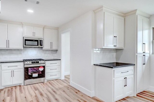 kitchen featuring appliances with stainless steel finishes, tasteful backsplash, light hardwood / wood-style flooring, and white cabinetry