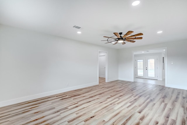 empty room with ceiling fan and light hardwood / wood-style flooring