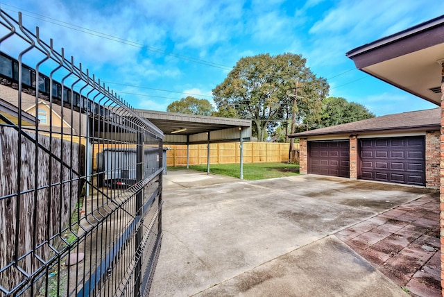 view of patio / terrace with a garage, an outdoor structure, and a carport