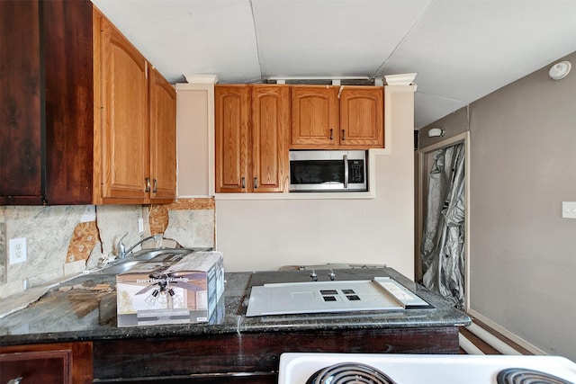 kitchen featuring tasteful backsplash and dark stone counters