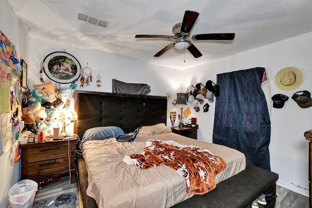 bedroom featuring wood finished floors, visible vents, and ceiling fan