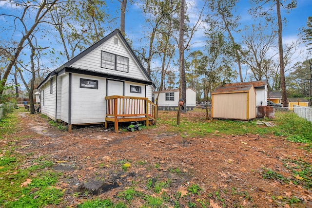 back of house featuring a shed