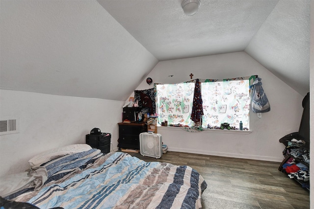 bedroom with a textured ceiling, dark hardwood / wood-style floors, and vaulted ceiling