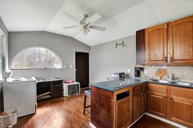 kitchen featuring dark wood-style floors, lofted ceiling, ceiling fan, a sink, and brown cabinets