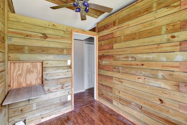 unfurnished bedroom with wooden walls and wood finished floors