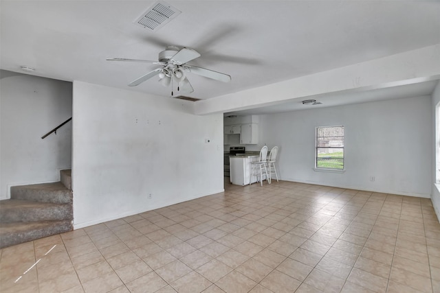 unfurnished living room with stairs, baseboards, visible vents, and ceiling fan