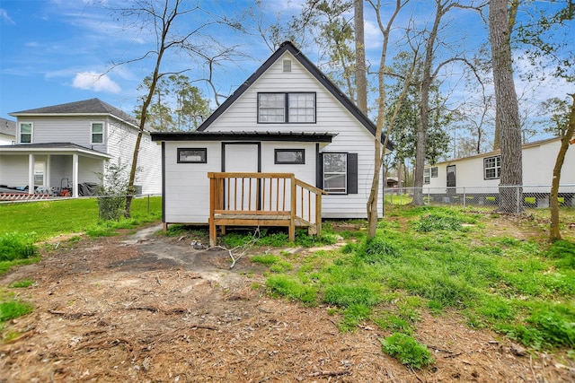 rear view of property with a yard and fence