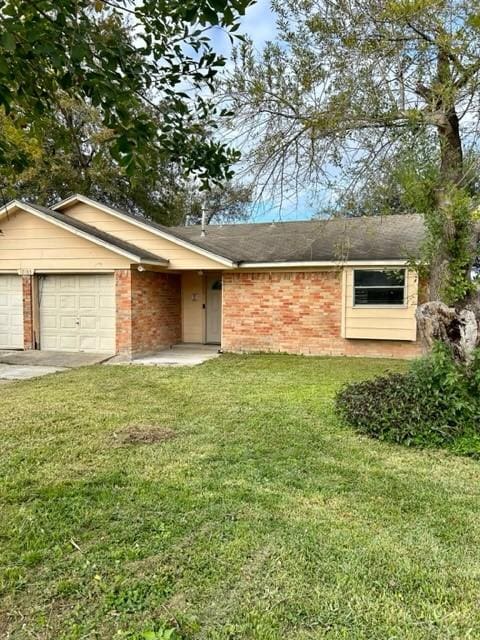 single story home featuring a garage and a front lawn