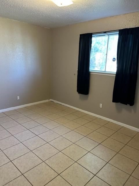 unfurnished room featuring a textured ceiling