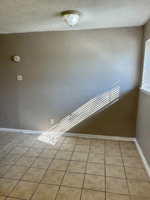 stairs with a textured ceiling and tile patterned flooring