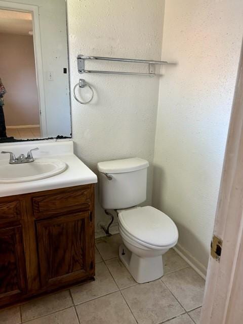 bathroom with tile patterned flooring, vanity, and toilet