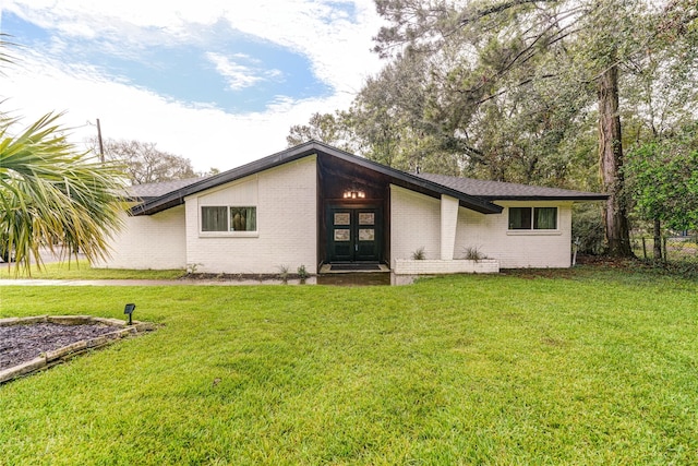 rear view of property featuring a lawn