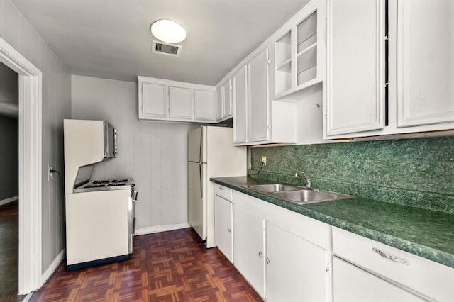 kitchen with dark parquet flooring, white appliances, white cabinetry, and sink