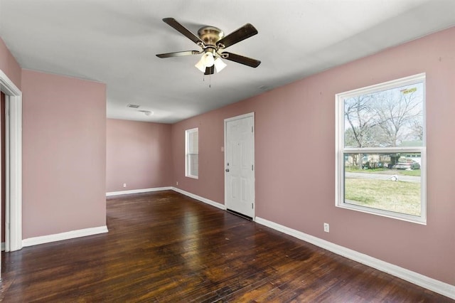 unfurnished room featuring dark hardwood / wood-style flooring, plenty of natural light, and ceiling fan