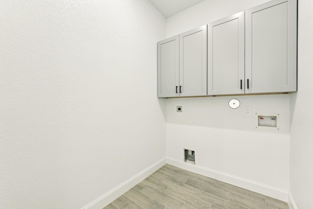 washroom with cabinets, washer hookup, light wood-type flooring, gas dryer hookup, and electric dryer hookup