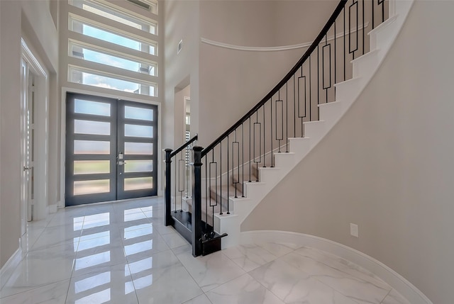 entrance foyer with french doors and a towering ceiling