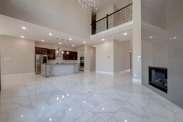 unfurnished living room featuring a towering ceiling