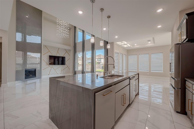 kitchen featuring sink, a center island with sink, decorative light fixtures, and appliances with stainless steel finishes