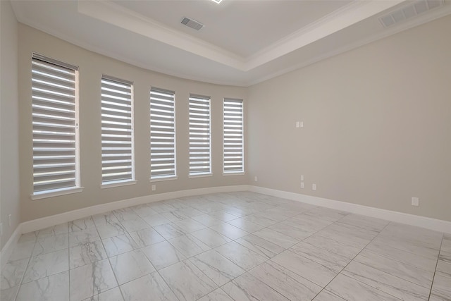 empty room featuring a raised ceiling and crown molding