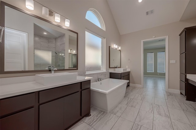 bathroom featuring vanity, a tile shower, and high vaulted ceiling