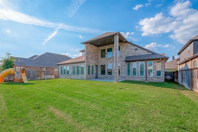 rear view of property with a lawn and a playground