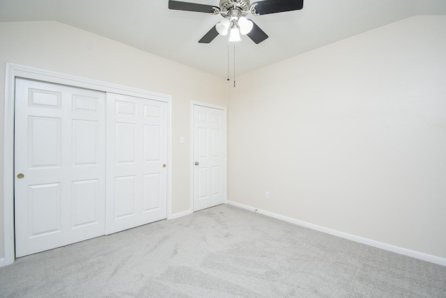 unfurnished bedroom with lofted ceiling, light carpet, a closet, and ceiling fan