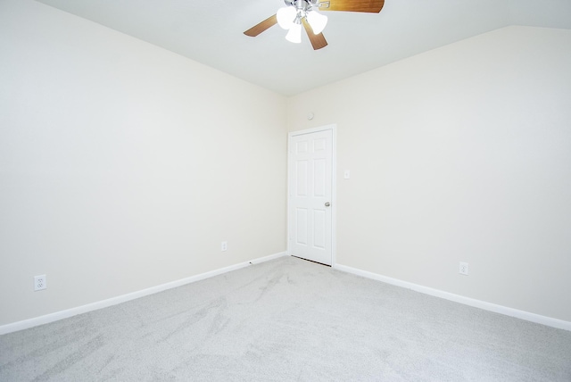 carpeted empty room with vaulted ceiling and ceiling fan