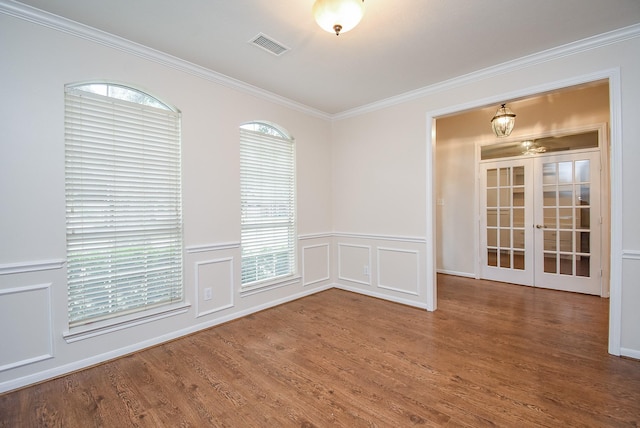 empty room featuring french doors, ornamental molding, and wood-type flooring